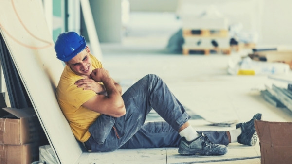 En bygningsarbeider ligger på gulvet etter å ha vært utsatt for en yrkesskade som han senere vil kreve en yrkesskadeerstatning for